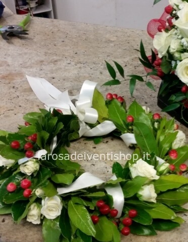 Coroncina d'alloro con roselline bianche, acche rosse e nastro in raso colori a scelta